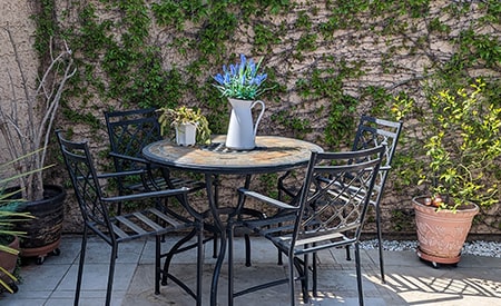 A metal black table with a lavendar centerpiece.